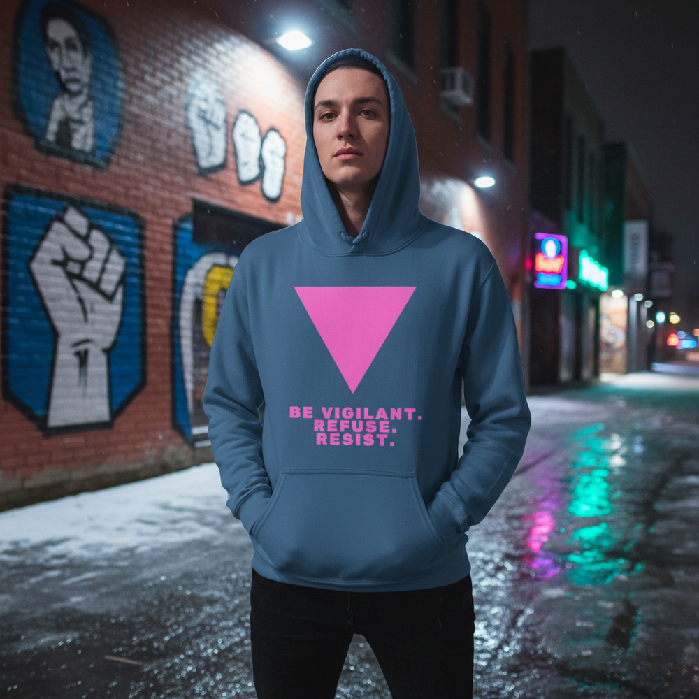 Person wearing a blue hoodie with a pink triangle and “BE VIGILANT. REFUSE. RESIST.”