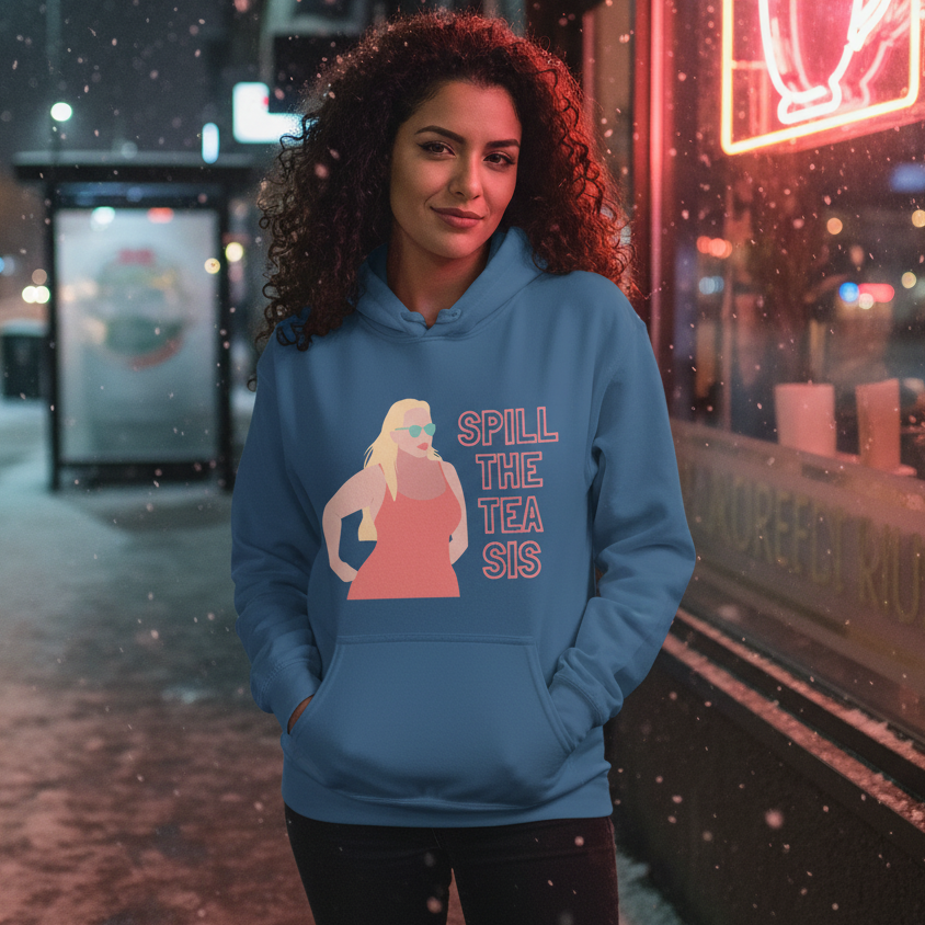 Model wearing a blue hoodie reading “SPILL THE TEA SIS” in a snowy neon-lit street