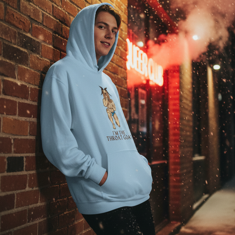 Young person outdoors at night in an I'm The Throat Goat Unisex Hoodie. The hoodie, featuring an illustrated anthropomorphic goat, embodies queer pride and self-expression with cozy comfort and playful boldness.