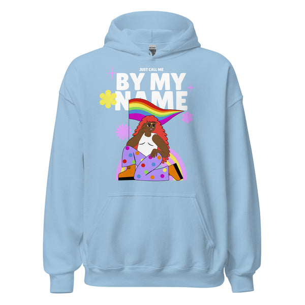Just Call Me By My Name Unisex Hoodie features a vibrant graphic of a red-haired figure in polka-dotted pants, embodying queer pride and self-expression with rainbow elements and bold lettering.