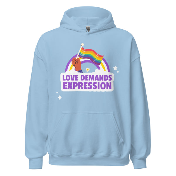 Love Demands Expression Unisex Hoodie features a hand holding a rainbow pride flag with a rainbow, cloud motif, bold LOVE DEMANDS EXPRESSION slogan, stars, and daisy accents, celebrating LGBTQ+ pride.