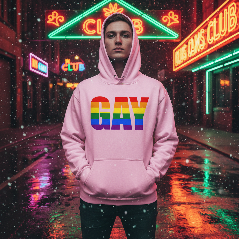 Person wearing a pink hoodie with rainbow-striped “GAY” lettering on a neon-lit rainy street