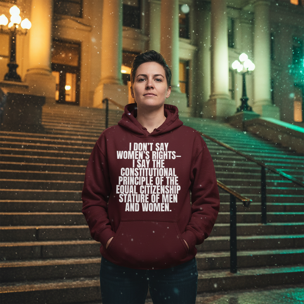 Person wearing a maroon hoodie with bold white constitutional-equality text on courthouse steps at night