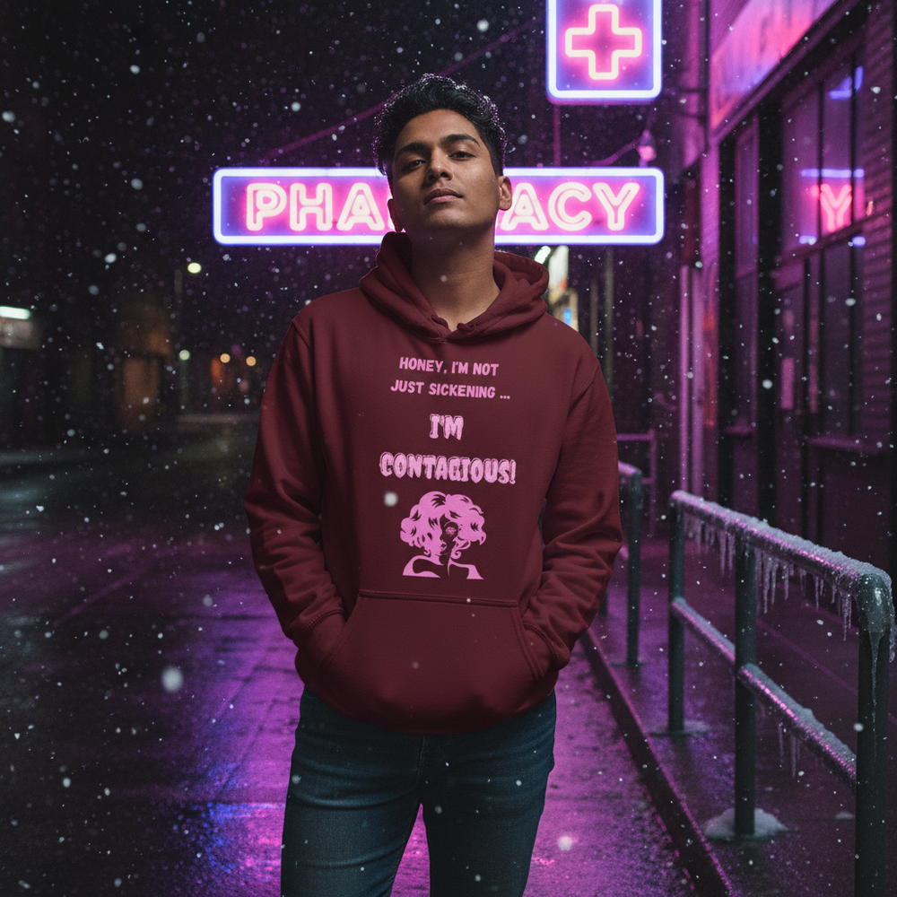 Person wearing a burgundy hoodie reading “Honey, I’m not just sickening… I’m contagious!” in falling snow