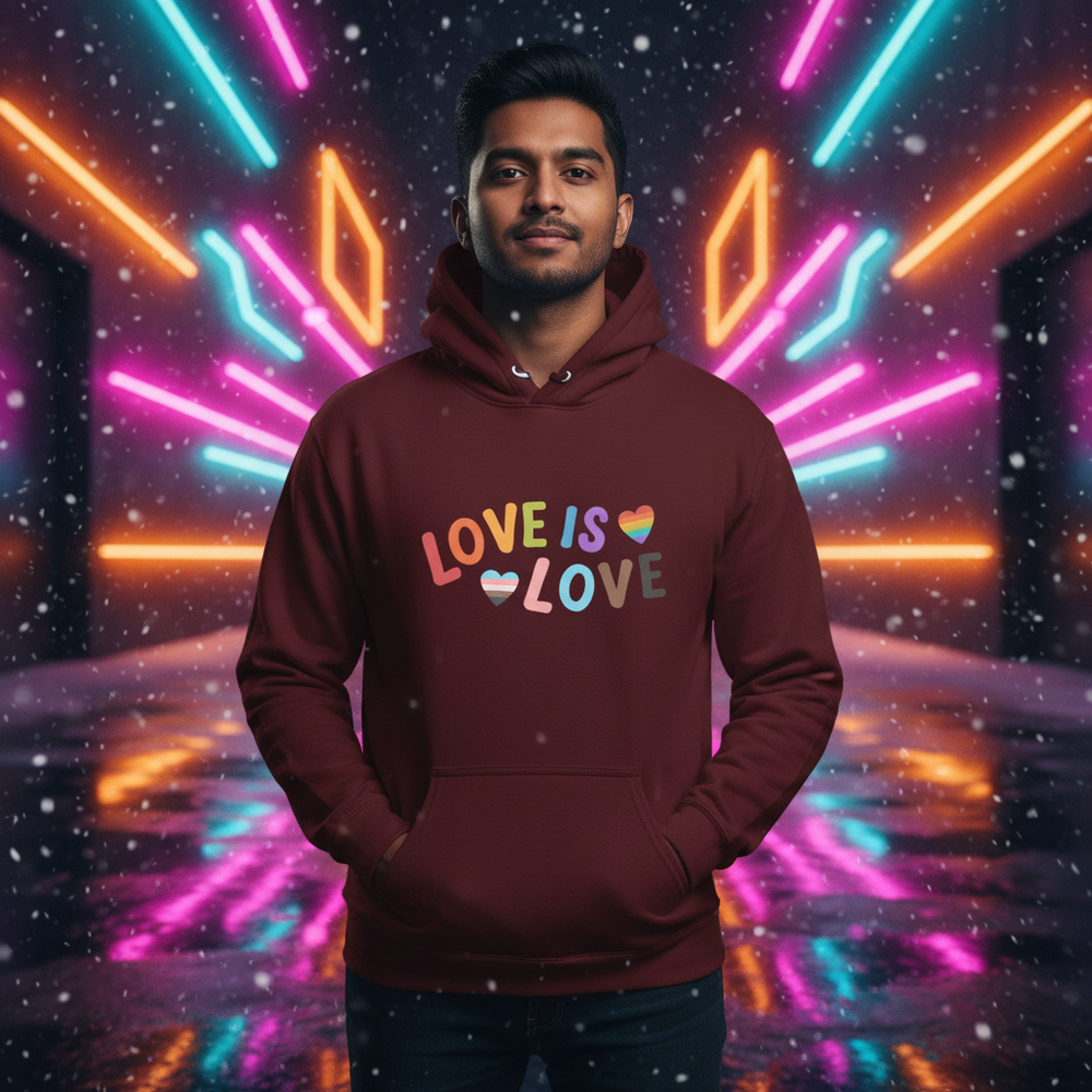 Model wearing a burgundy hoodie reading “LOVE IS LOVE” with rainbow and striped hearts