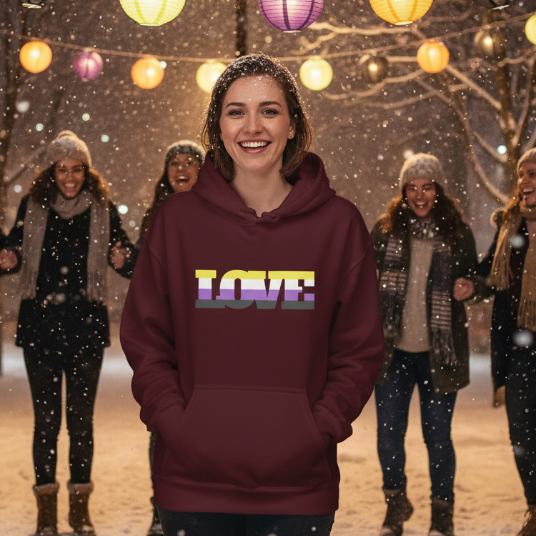 Smiling person in a burgundy hoodie with a multicolor LOVE graphic, outdoors in falling snow