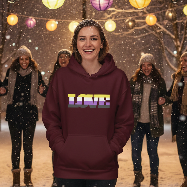 Smiling person in a burgundy hoodie with a multicolor LOVE graphic, outdoors in falling snow