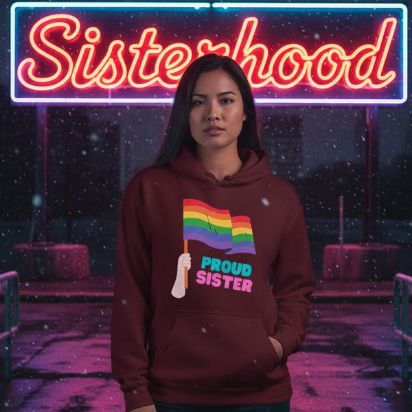 person wearing a burgundy hoodie with rainbow flags and “PROUD SISTER” text