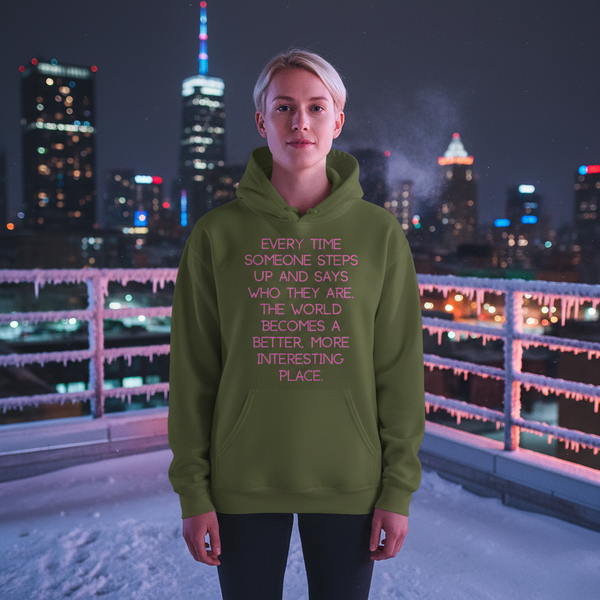 Person wearing an olive hoodie with pink quote text on a snowy city rooftop at night