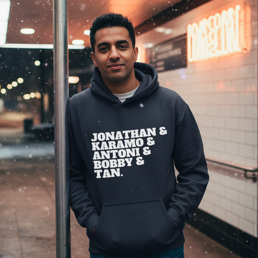 Person wearing a dark hoodie reading “JONATHAN & KARAMO & ANTONI & BOBBY & TAN.”