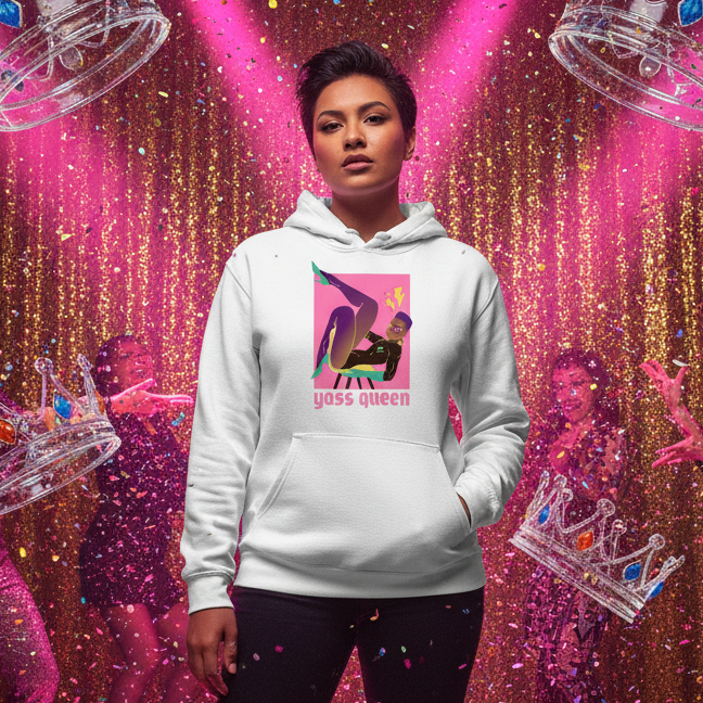 Yass Queen Unisex Hoodie worn by a person under pink spotlights, featuring a stylized figure and empowering text, against a vibrant club-like backdrop, embodying joyful, inclusive queer self-expression.