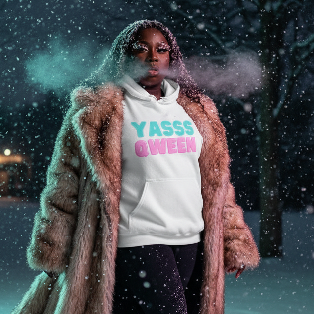 Person in snow wearing Yasss Qween Unisex Hoodie under fur coat, breath visible, embodies queer pride and self-expression with cozy, eye-catching style, perfect for cool nights and diverse identities.