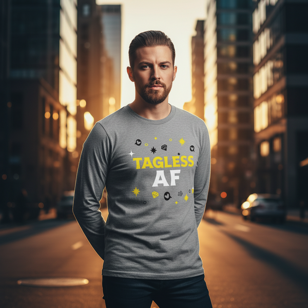 Bearded person wearing a gray long-sleeve shirt reading “TAGLESS AF” on a city street