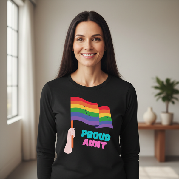 Smiling person models a black long-sleeve shirt with rainbow flags and “PROUD AUNT” text