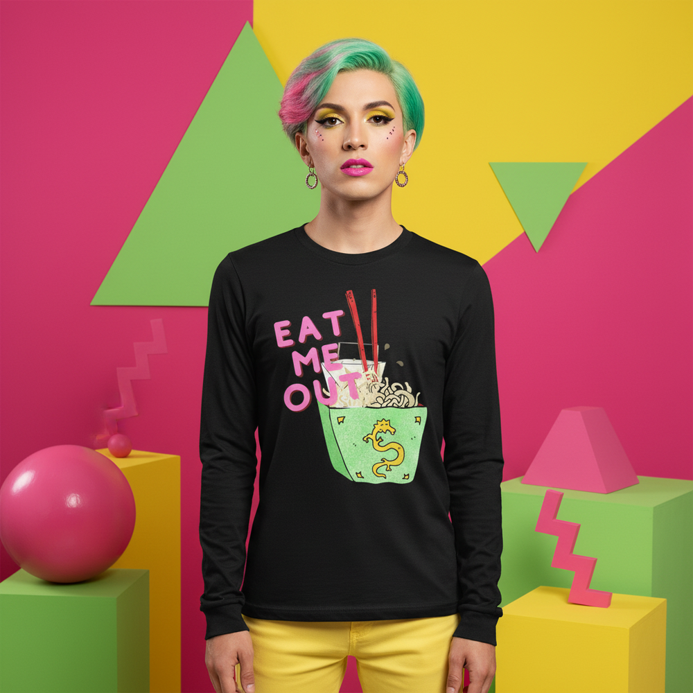 Front-facing model wearing a black long-sleeve shirt reading “EAT ME OUT” with a noodle bowl graphic