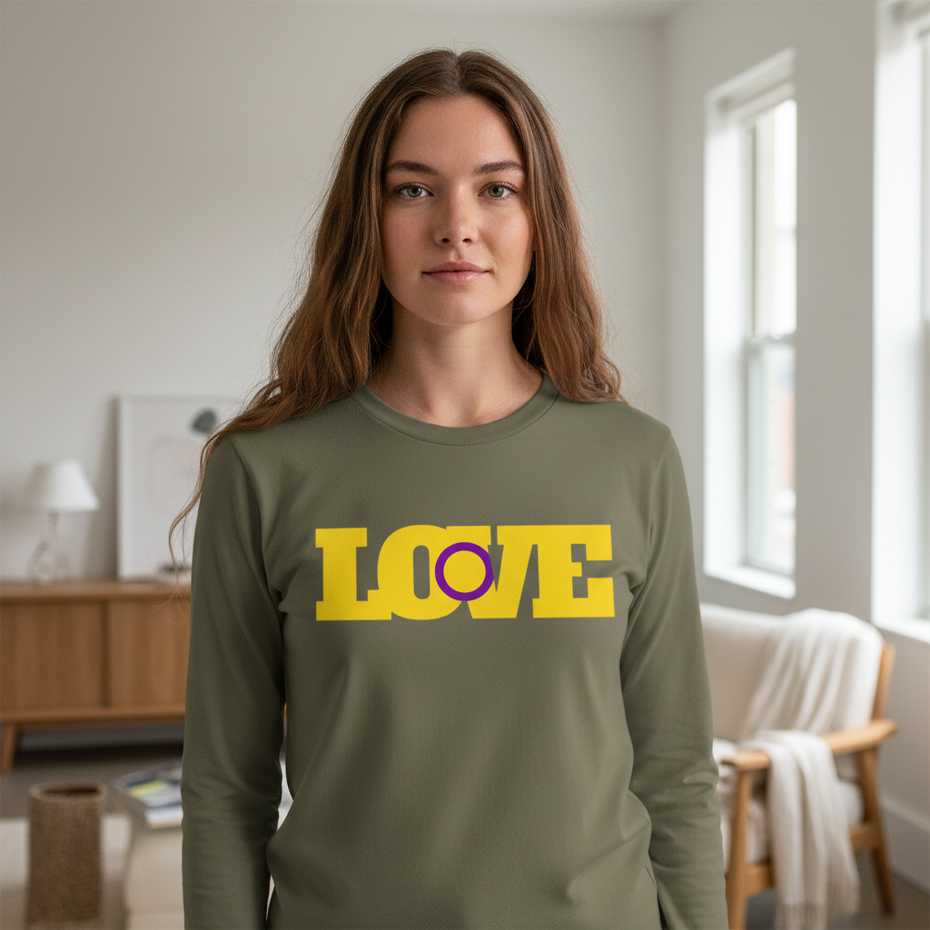 Young woman wearing the Intersex Love Unisex Long Sleeve T-Shirt, showcasing bold yellow “LOVE” text with a purple circle “O,” symbolizing pride and self-expression in a minimalist living room.