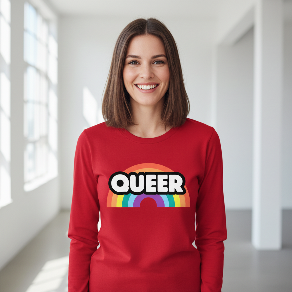 Smiling person wearing a red long-sleeve shirt with “QUEER” over a rainbow graphic