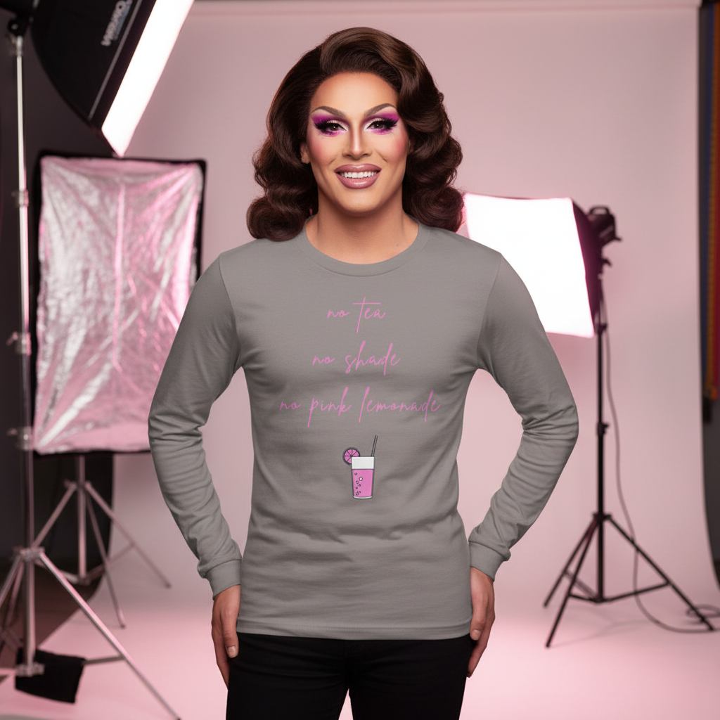Person showcasing the No Tea No Shade No Pink Lemonade Unisex Long Sleeve T-Shirt with bold pink script, styled hair, and dramatic makeup, exuding vibrant queer pride and self-expression in a pink-hued studio setting.