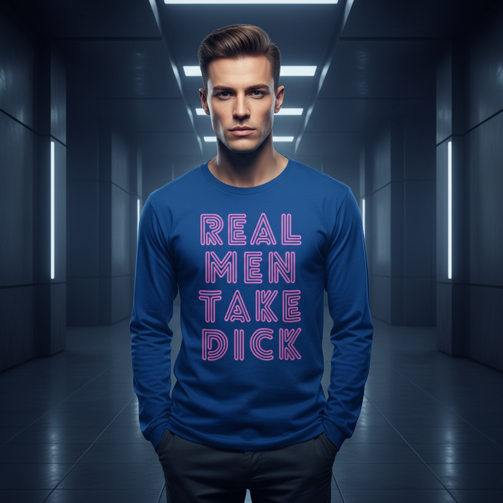 Young man wearing the Real Men Take Dick Unisex Long Sleeve Tee, exuding queer pride and self-expression in a dim, futuristic hallway, hands in pockets, confidently embracing LGBTQIA+ identity.