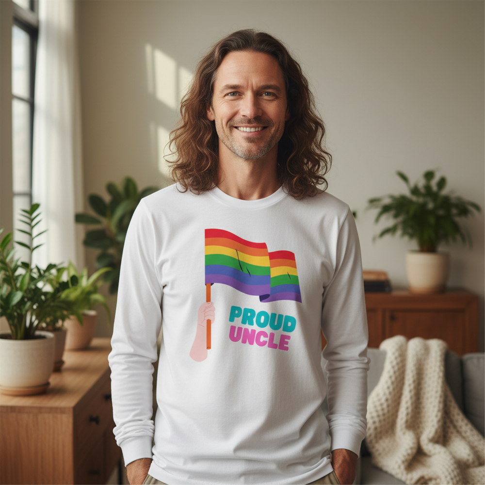 Smiling person modeling a white long-sleeve shirt with rainbow flags and “PROUD UNCLE” text
