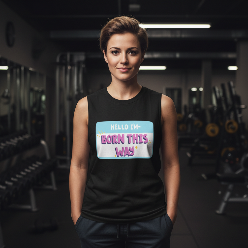 Unisex relaxed fit muscle tank with a bright "Hello I'm Born This Way" name tag graphic, worn in a softly lit gym.