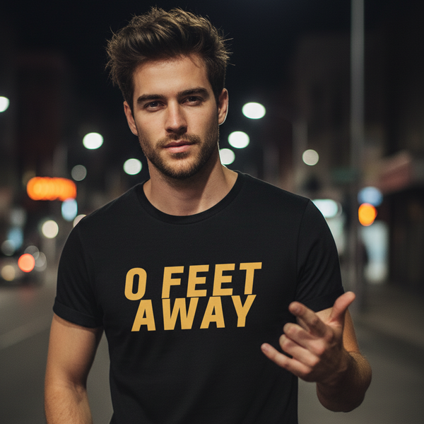 person wearing a black T-shirt reading “0 FEET AWAY” in yellow lettering