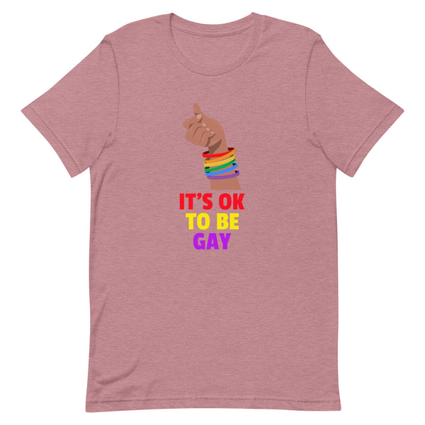 Dusty-rose It's OK To Be Gay T-Shirt featuring a hand with rainbow wristbands making a heart gesture, paired with bold rainbow text. A celebration of queer pride and self-expression.