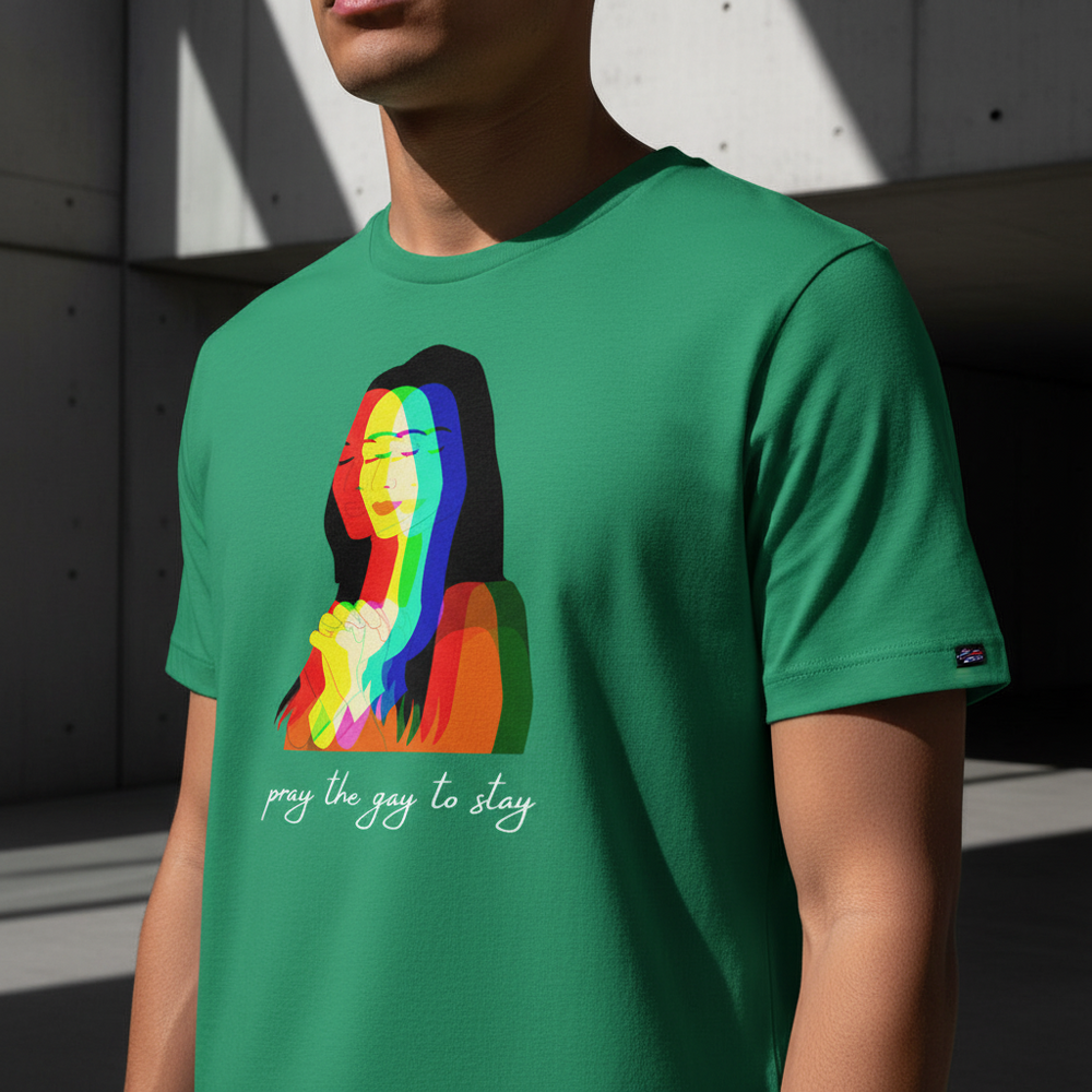 Front view of a green T-shirt with a rainbow praying figure and “pray the gay to stay”