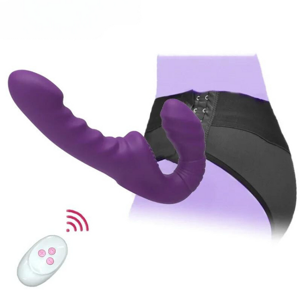 Purple strapless dildo attached to black harness with a white remote control