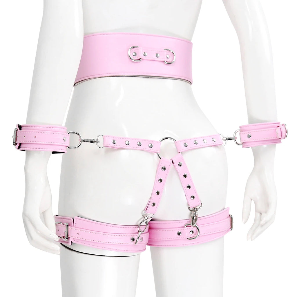 Pink strappy body harness with wrist cuffs, thigh straps, rings, and silver studs on a mannequin