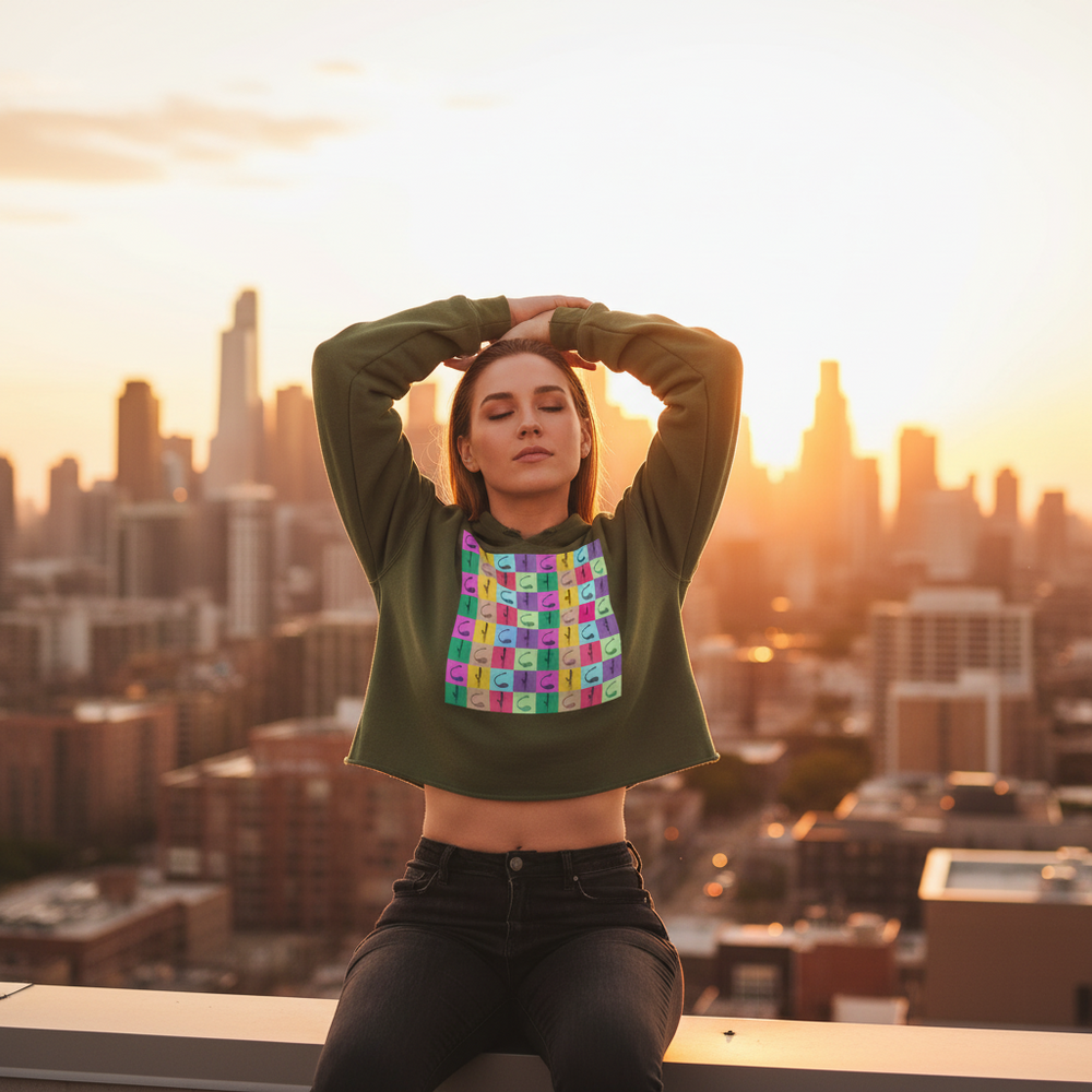 Vibrator Pop Art Crop Hoodie in bold, vibrant colors worn by a woman on a rooftop at sunset, city lights flaunt queer style.