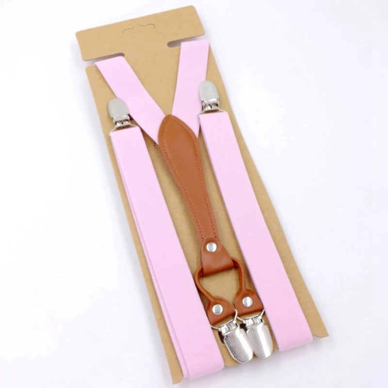 Pink Y-back suspenders with brown leather center strap and silver clips on cardboard packaging