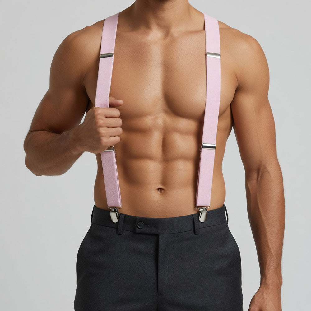 Front view of a shirtless model wearing pink suspenders with silver clips over black trousers