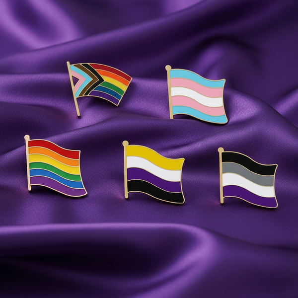 Five enamel pride flag pins arranged on rippled purple fabric