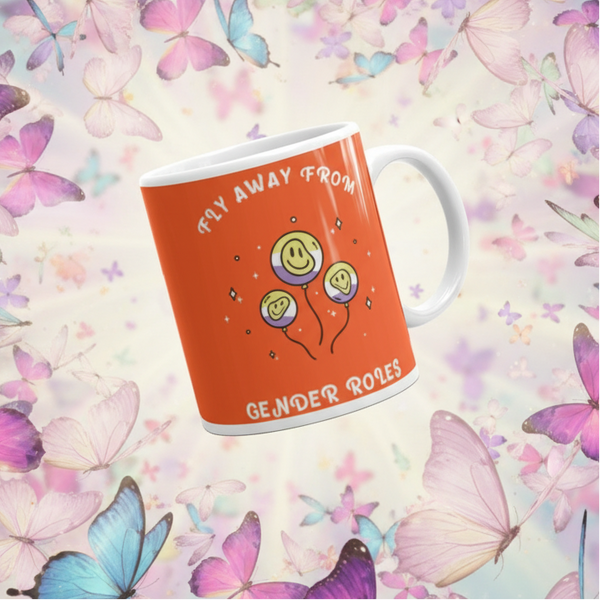 Ceramic mug with three smiley-face balloons and Fly Away From Gender Roles slogan, embodying queer pride and self-expression. Ideal for showcasing LGBTQIA+ identity. Dishwasher and microwave safe.