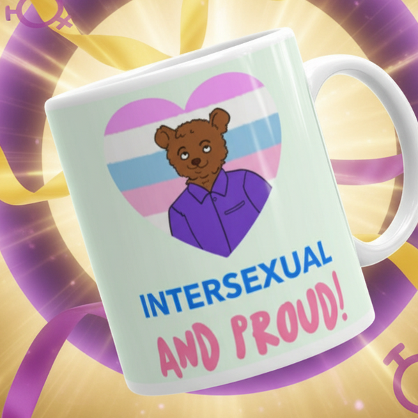 Intersexual And Proud Mug: A white ceramic mug featuring a cartoon bear inside a pink-white-blue heart with empowering slogan, surrounded by golden light rays and intersex-symbol-adorned purple ribbons. Perfect for expressing pride.