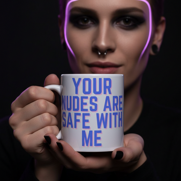 A person presents the Your Nudes Are Safe With Me Mug, a bold statement piece in white ceramic with vibrant lettering, embodying queer pride and self-expression. Ideal for coffee, tea, or wine moments.