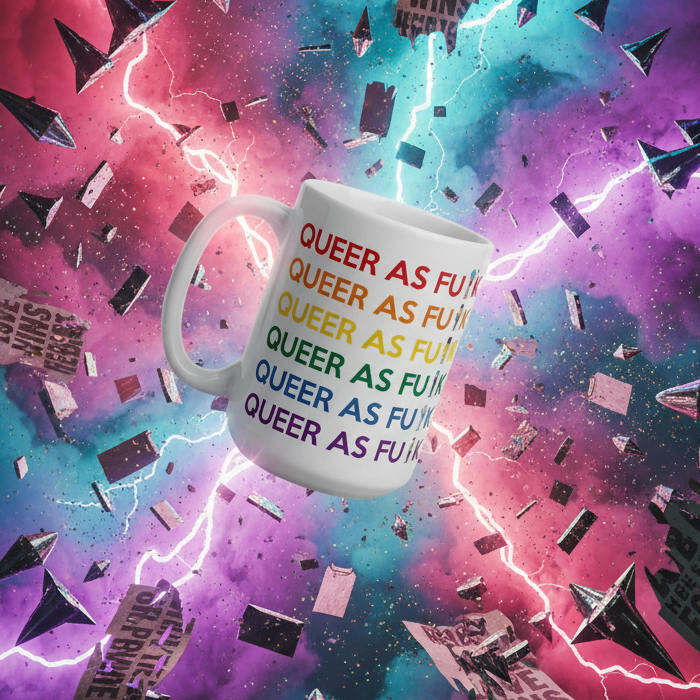 Close-up of a white mug printed with colorful repeated “QUEER AS F*CK” text