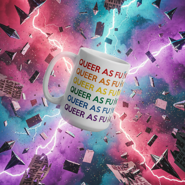 Close-up of a white mug printed with colorful repeated “QUEER AS F*CK” text