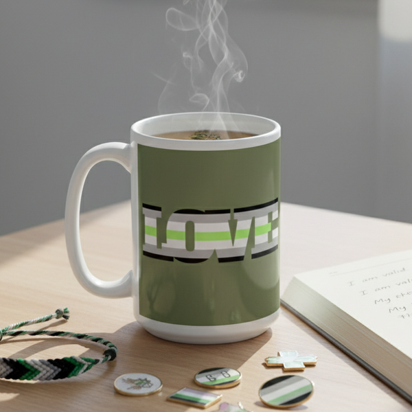 Agender Love Mug on a desk, featuring aromantic-pride colors and LOVE text. Surrounded by a notebook, friendship bracelet, and enamel pins, celebrating queer pride and self-expression. Steam rises from hot coffee.