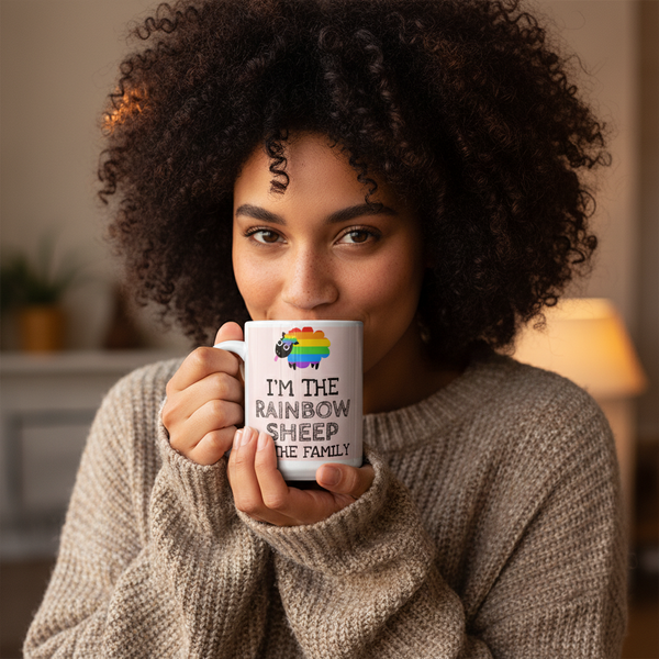 Young woman holds I'm The Rainbow Sheep Of The Family mug with rainbow-striped sheep illustration, embodying LGBTQIA+ pride and self-expression, suggesting a cozy, empowering vibe. Perfect for showing identity with every sip.