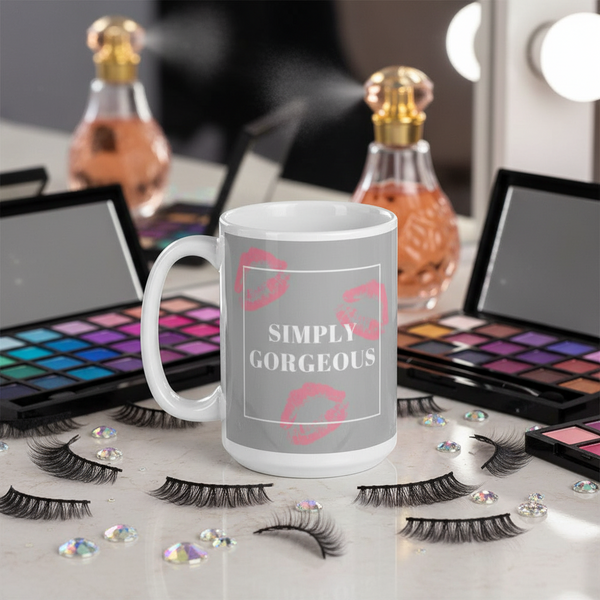 White mug reading “SIMPLY GORGEOUS,” with pink lip prints, surrounded by makeup and false eyelashes
