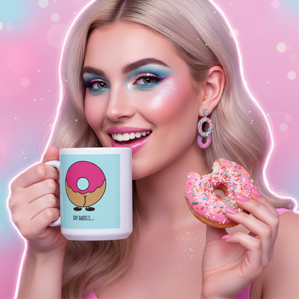 Person holds a mug with a cartoon bagel and “GAY BAGELS...” text beside a pink-frosted doughnut