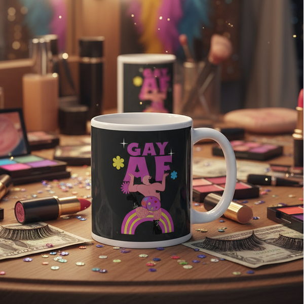 Ceramic Gay AF Mug with playful rainbow design and cartoon figure, surrounded by cosmetics on a vanity—perfect for celebrating queer pride with every sip.
