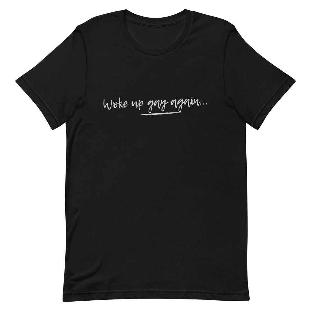 Front view of a black T-shirt with white script reading “Woke up gay again…”