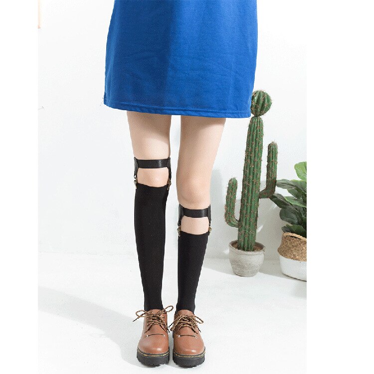 Model wearing black thigh-high stockings with buckle garter straps and brown lace-up shoes
