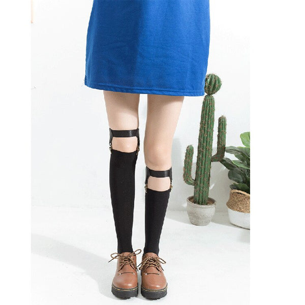 Model wearing black thigh-high stockings with buckle garter straps and brown lace-up shoes