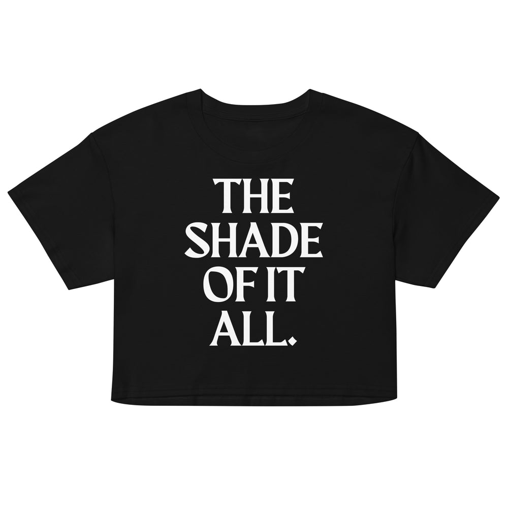Front view of a black cropped T-shirt with white text reading “THE SHADE OF IT ALL.”