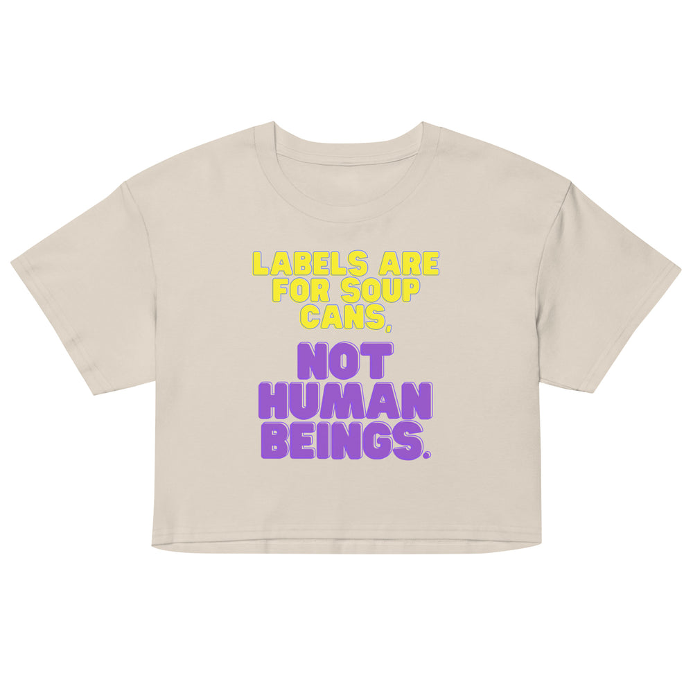 Front-view beige crop top reading “LABELS ARE FOR SOUP CANS, NOT HUMAN BEINGS.”