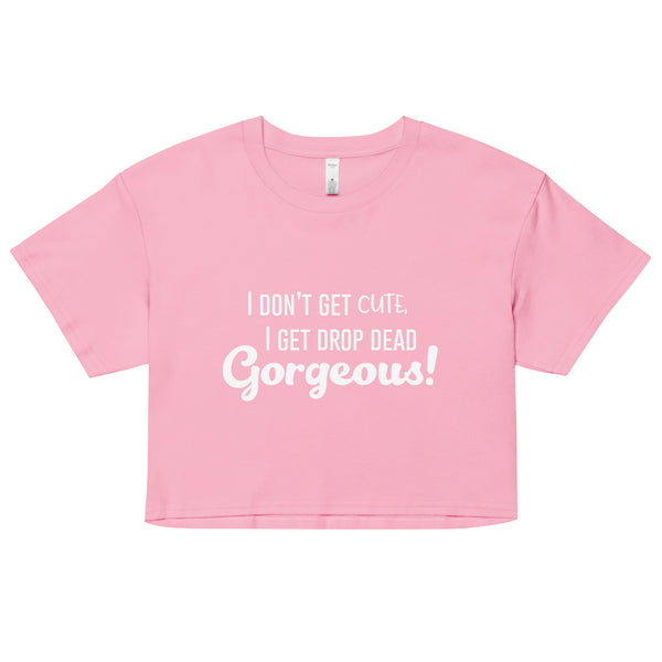 Flat-lay pink crop top with white text, “I DON’T GET CUTE, I GET DROP DEAD GORGEOUS!”